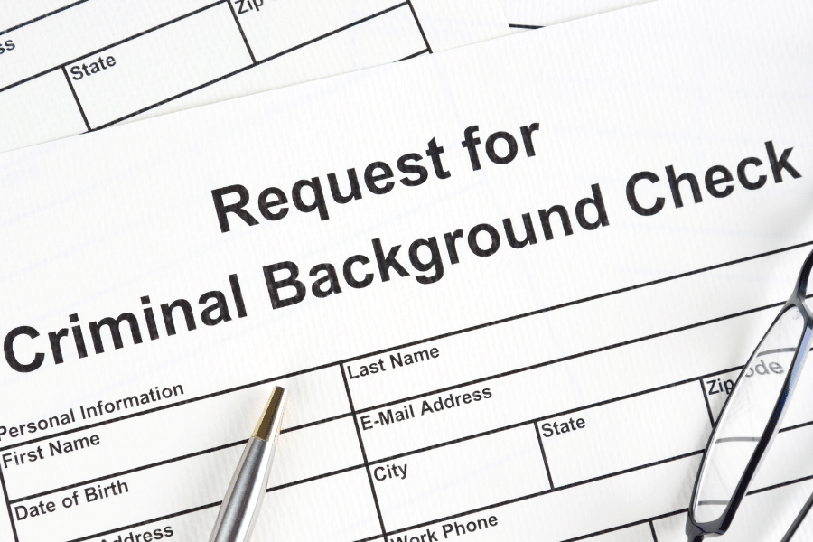 Criminal Background Check paper with a pen and glasses