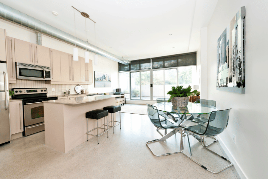 beautiful kitchen in a condo with new appliances and a glass kitchen table